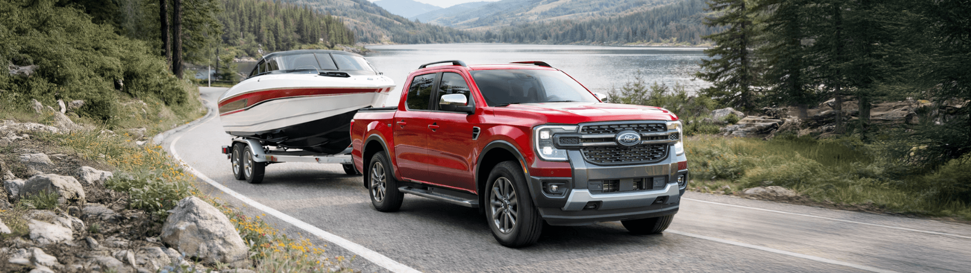 Ford Ranger towing a boat through a lakeside forest.